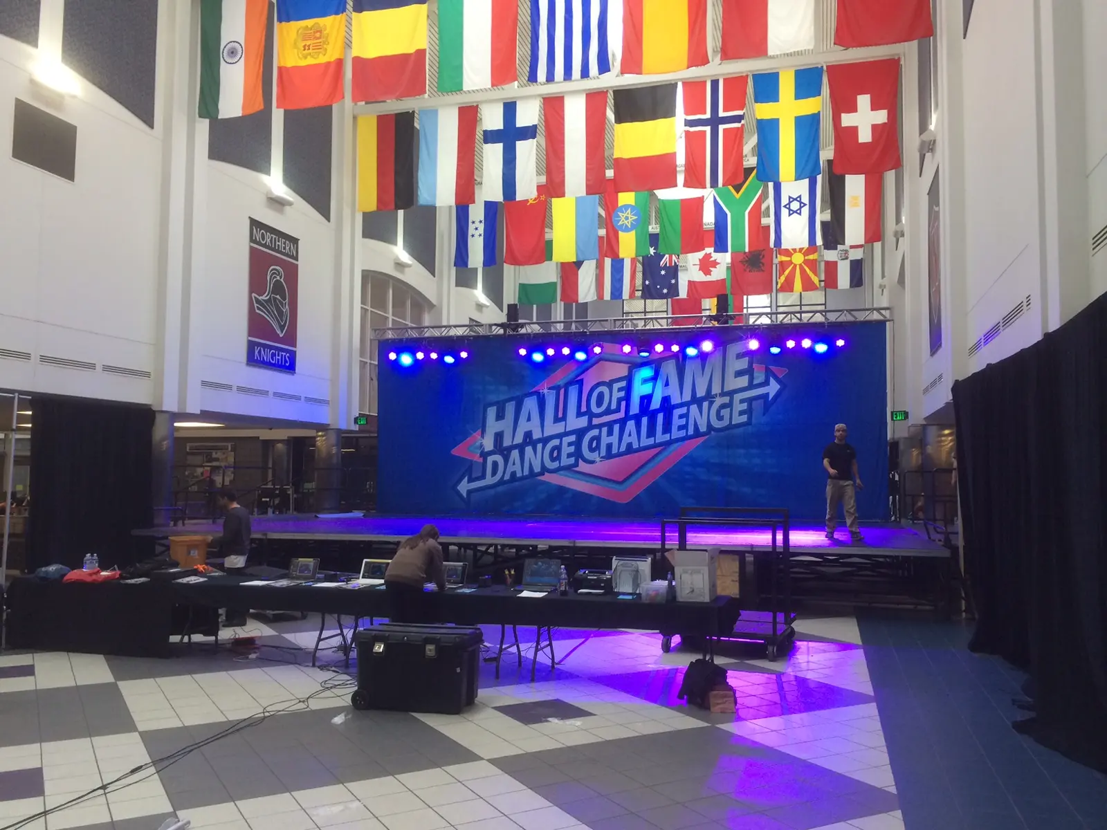 A dance competition stage with a lit Hall of Fame Dance Challenge backdrop