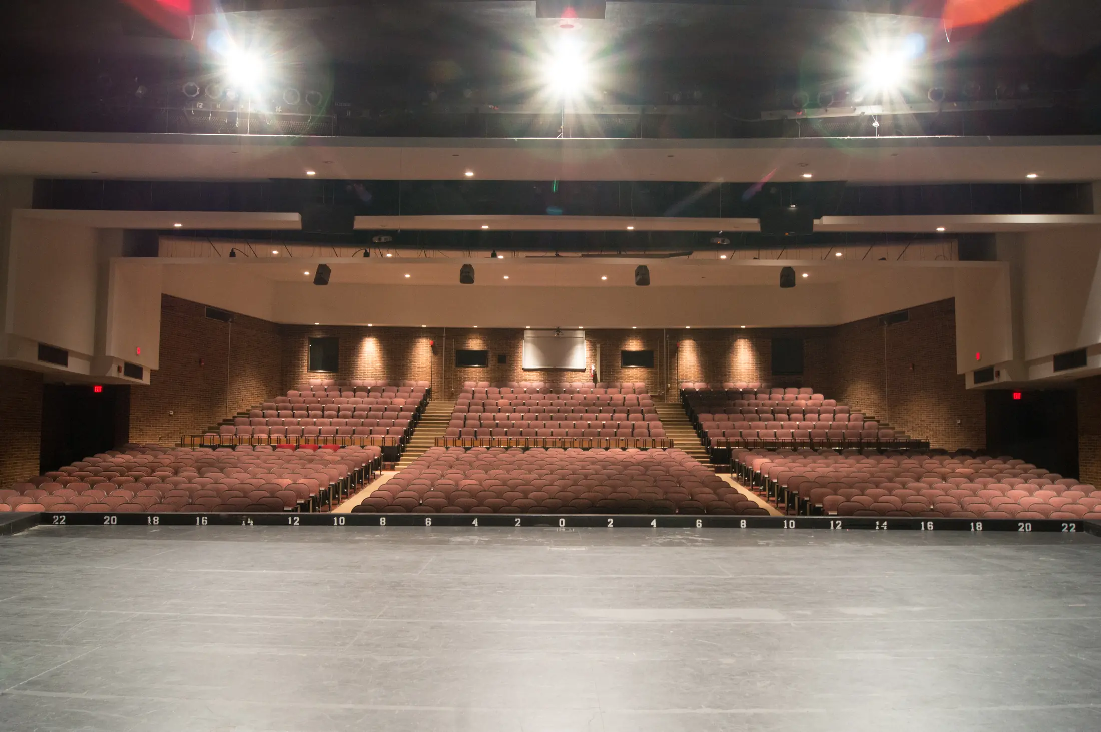 Walled Lake Western auditorium from the stage, warm wood walls and lit seating